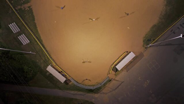 Top view of a baseball field at night with players playing American baseball.Canada.Halifax.Men and women play baseball. Catcher learns to catch a baseball while throwing a ball 