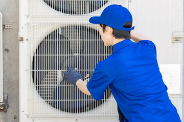 Worker inspecting the outdoor unit