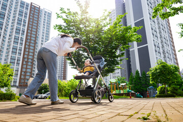한국의 아파트단지에서 유모차에 아기를 태우고 산책하는 엄마