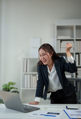 Successful businesswoman, happy, showing fighting pose Dancing after receiving news Successful business approval results on laptop in office Startup business idea, time online.