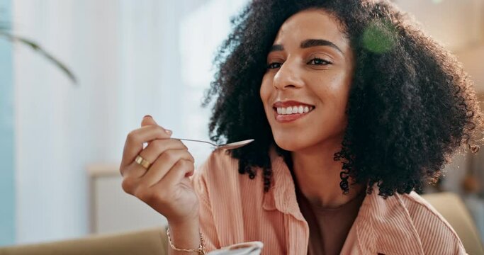 Happy, woman and eating yogurt with spoon on sofa for healthy food, nutrition and balanced diet at home. Female person, detox and weight loss with snack or dessert alternative on couch for wellness
