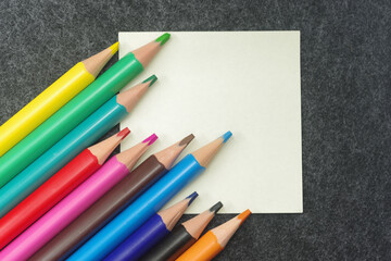 Pencils in different colors and clips on grey background