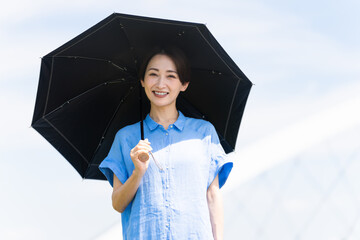 日傘をさして散歩する若い女性　ライフスタイルイメージ