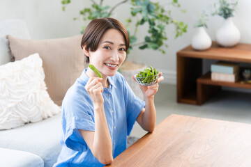 枝豆を食べる若い女性　ライフスタイルイメージ