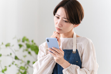 エプロン姿で料理する若い女性　ライフスタイルイメージ