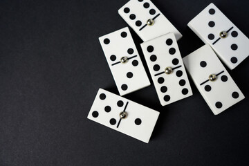 white domino blocks on black background. There are some benefits of playing domingo; helps to develop critical thinking skills, bond with families and social groups, reduces stress, improve memory.