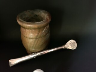 Wooden gourd and stainless steel bombilla for mate drinks. Yerba mate cup and stainless steel on black background. Mate the national beverage of Paraguay.