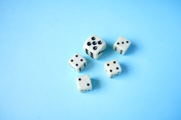 White dices on blue background.The Dice game is one of the oldest of all the games in the world and. It can play by all of ages of player. Top view of dices.
