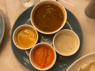 A tantalizing closeup reveals bowls brimming with an array of vibrant South Indian chutneys and a rich sambhar.