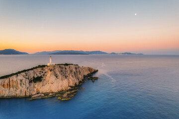 Fototapeta premium Lighthouse on the cliff. Seascape of Cape Lefkatas with old lighthouse on Lefkada island, Greece. Beautiful views of azure sea water and nature with cliffs