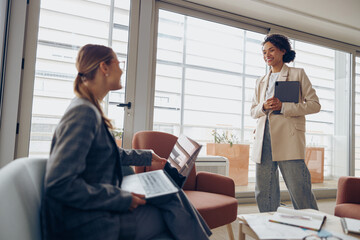 Human resources manager in eyewear sitting at office is making welcome sign to candidate on job