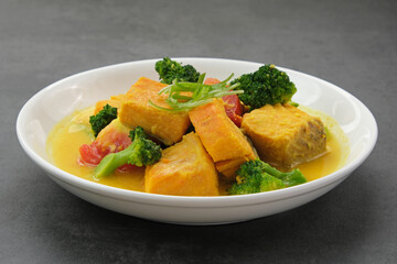 Salmon Kuah Kuning, fish soup with broccoli and tomatoes. Indonesian food
