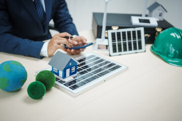 A professional man works on solar panel installation, focusing clean energy solutions. He reviews blueprints and designs in an office setting innovative construction development for a modern house.