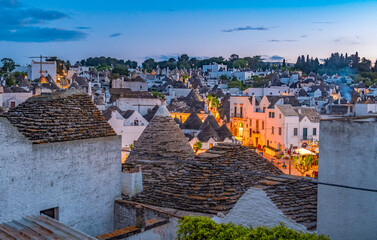 Trulli of Alberobello, Puglia, Italy. town of Alberobello with trulli houses among green plants and...