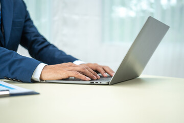 A banker in a suit works at a desk handling loans, analyzing client financial data, providing financial advice, dealing with stocks and the stock market, and studying economic situations.