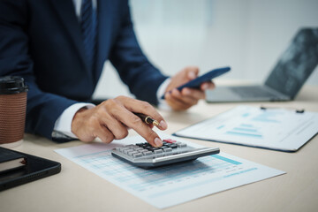Fototapeta premium A banker in a suit works at a desk handling loans, analyzing client financial data, providing financial advice, dealing with stocks and the stock market, and studying economic situations.