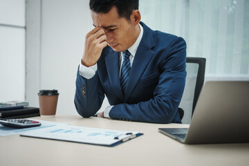 A banker in a suit works at a desk, handling loans, analyzing client financial data, providing...