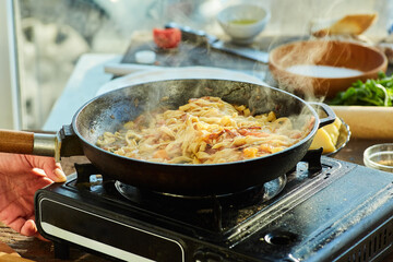 Step-by-step cooking process. Fry the cooked homemade noodles in a frying pan with fried tomatoes, onions and sausage