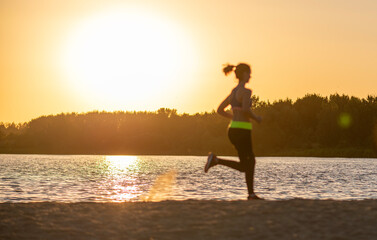 person running on the beach at sunset