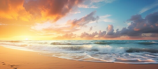 Obraz premium Sunrise over a serene beach with a scenic seascape and fluffy clouds in the sky, perfect for a summer vacation with a peaceful ambiance and copy space image.
