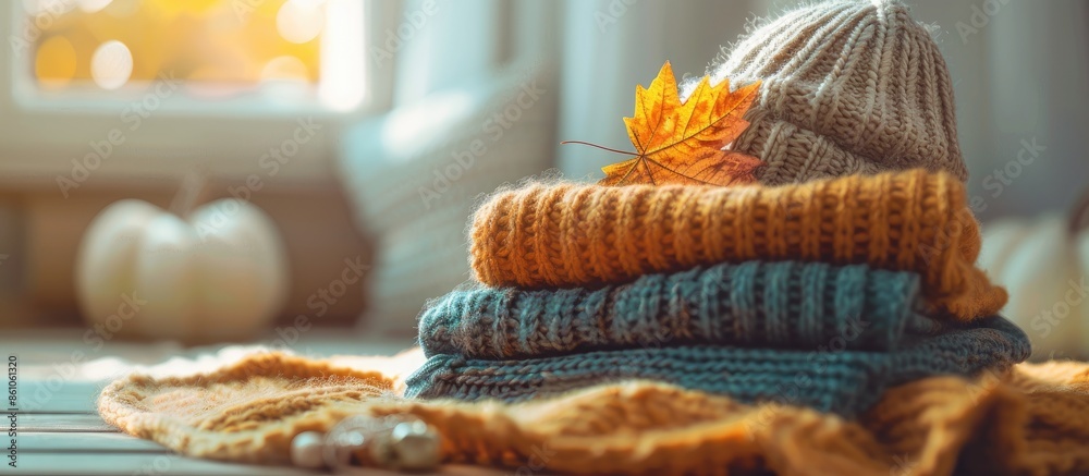 Poster stack of cozy knitted warm sweater with autumn fall maple leaf and beige stylish hat. sweaters in re