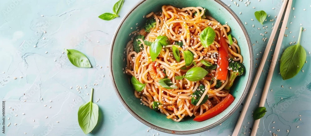 Aufkleber bowl of tasty rice noodles with vegetables and sesame seeds on pastel background. with copy space im