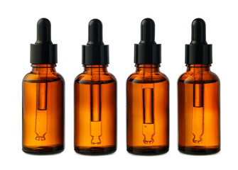 Four Amber Glass Bottles With Black Caps on a White Background