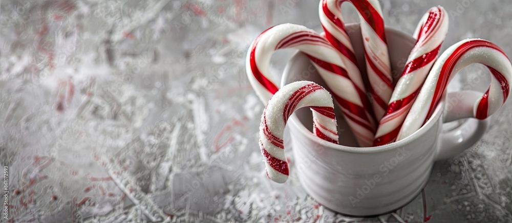 Fototapete Red and white candy canes in a cup on a gray pastel background. with copy space image. Place for adding text or design