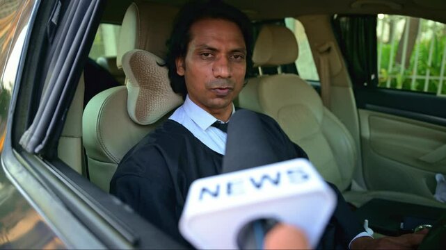 Lawyer in car being interviewed by news reporter
