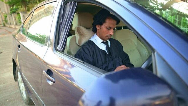 Lawyer sitting in car using mobile phone