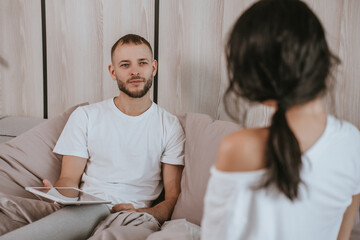 Obraz premium woman in black workout outfit leans on a ballet barre in bright studio. She has long blonde hair tied back and looks thoughtful