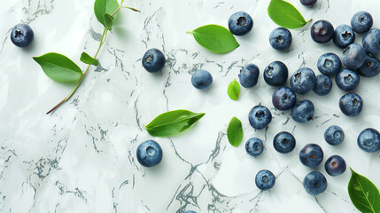 Fresh blueberries and green leaves on marble surface..