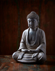 Meditating Buddha Statue on dark background. Soft focus. Close up. Copy space.	