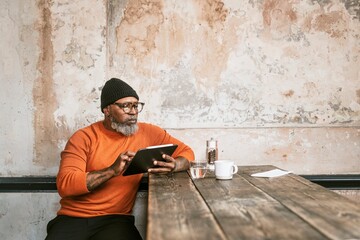 Fototapeta premium African American man using tablet at coffee shop
