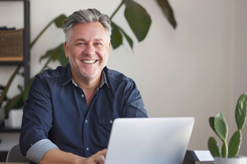 Caucasian Man in his 50's smiling at the camera, with a laptop in front of him, realistic, soft office background