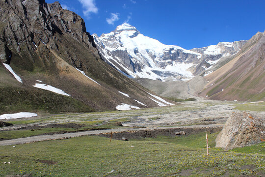 a view of adi kailash mountain surrounded by mountain range and meadows