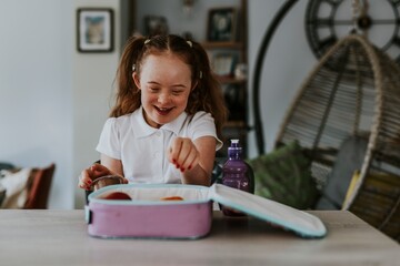 Down syndrome girl unpacking lunch bag