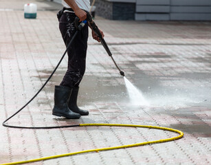 A man washes paving slabs with water