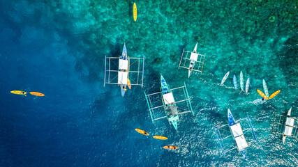 Top View from above  Bangka boat in front of a white sand beach bathed by a turquoise water. Coron Island, Palawan, Philippines.