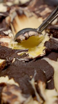 Chocolate-vanilla ice cream with serving spoon. Frozen sweet dessert concept.