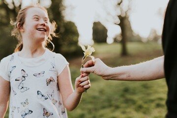 Fototapeta premium Down syndrome girl receiving flower