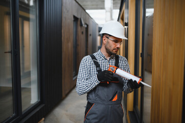 A worker installs windows in a new modular home. The concept of a new home