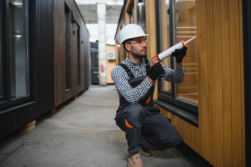 A worker installs windows in a new modular home. The concept of a new home