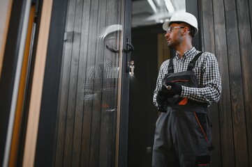 A worker or engineer in a uniform works on a construction site for the manufacture of wooden...