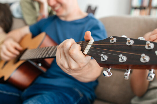 Close-up hand of man on guitar chords at home