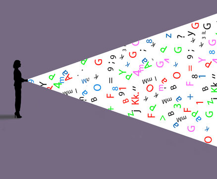 Symbols, numbers and letters illuminated by flashlight held by woman