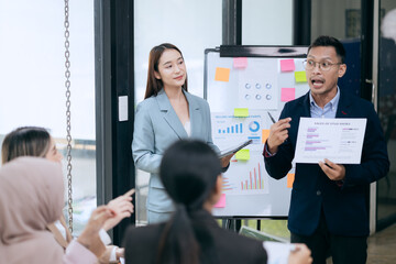 Professional business people taking part in a business meeting Discussing finances, strategies, and investing, they analyze charts on laptops. Demonstrate teamwork and effective communication.