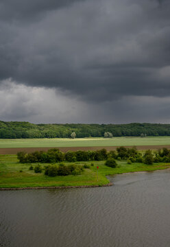 Floodlands near river Nederrijn under storm cloud in Netherlands