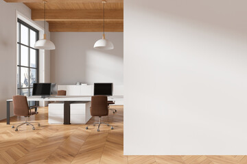 Coworking interior with pc monitors on tables, panoramic window. Mockup wall