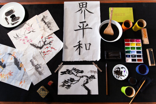 Drawings and paintings with art equipments kept on table